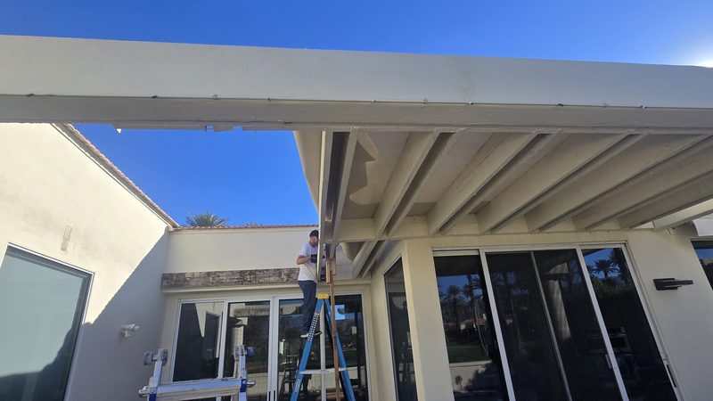 New patio cover installation worker on ladder Palm Desert